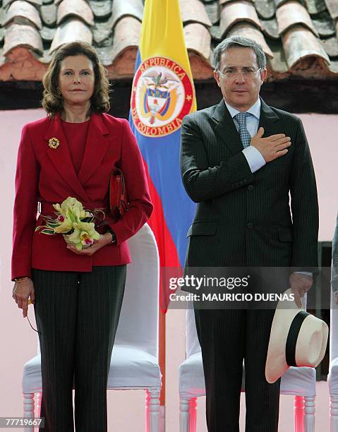 Colombian President Alvaro Uribe and Queen Silvia of Sweden listen to the national anthem during the opening ceremony of a biodiesel plant's...