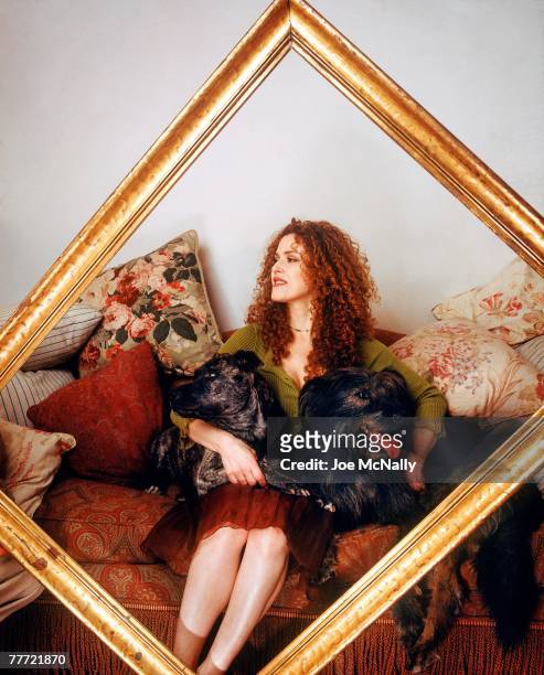 Bernadette Peters poses in a picture frame with her dogs during the winter of 1995 at her apartment in New York City. Peters, an award winning singer...