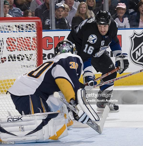 Jason Ward of the Tampa Bay Lightning tries to knock the puck past goaltender Ryan Miller of the Buffalo Sabres at St. Pete Times Forum on October...