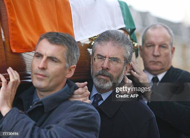 President of Sinn Fein Gerry Adams helps to carry the coffin of Martin Meehan as he is escorted by the Republican colour guard during a funeral...