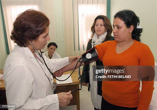 By Hamida BEN SALAH - Tunisie-Politique-anniversaire-20ans - Tunisian doctor Moussa takes a patient's blood presure during a consultation in a...