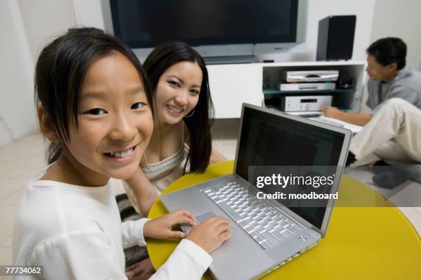family in living room using laptop and home theater system - loose wires stock pictures, royalty-free photos & images