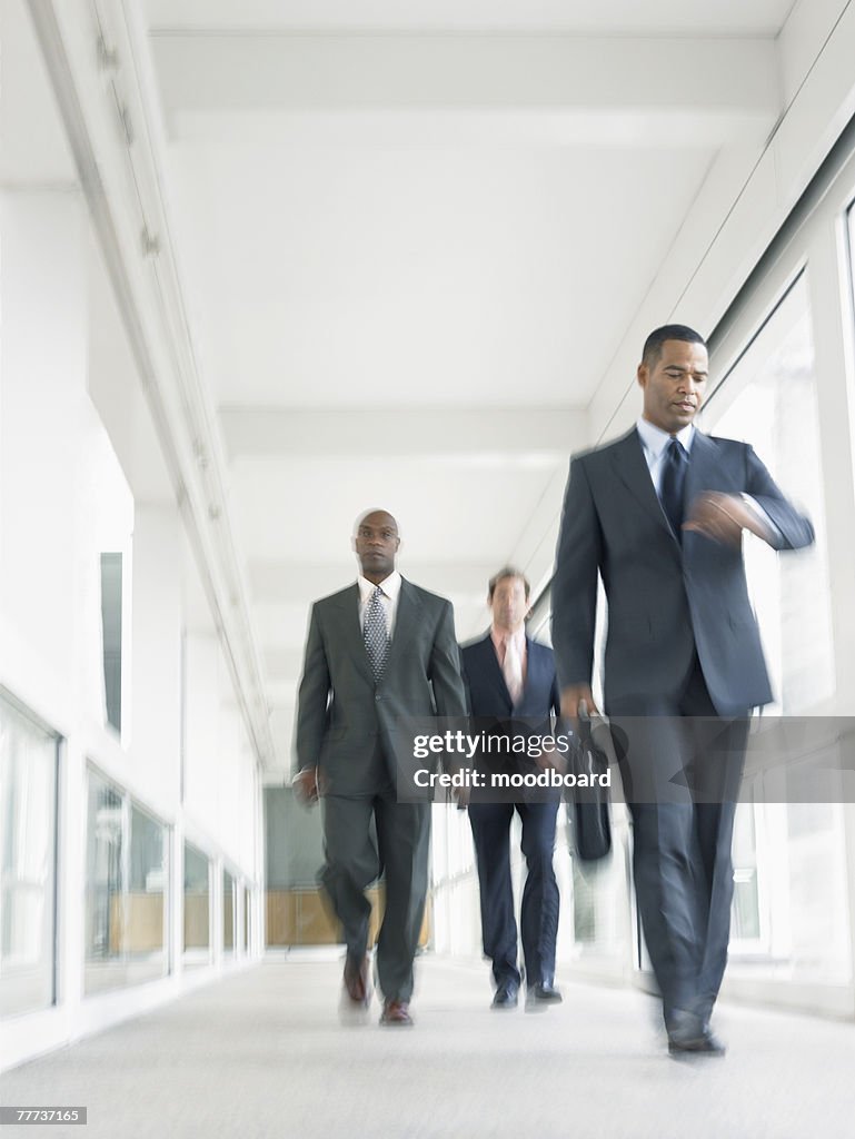 Hurried Businessmen Walking Down Corridor