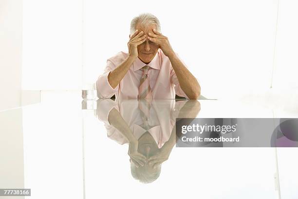 stressed businessman sitting at table - double facepalm stock pictures, royalty-free photos & images