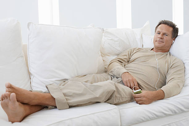 Man Listening to mp3 player on Sofa