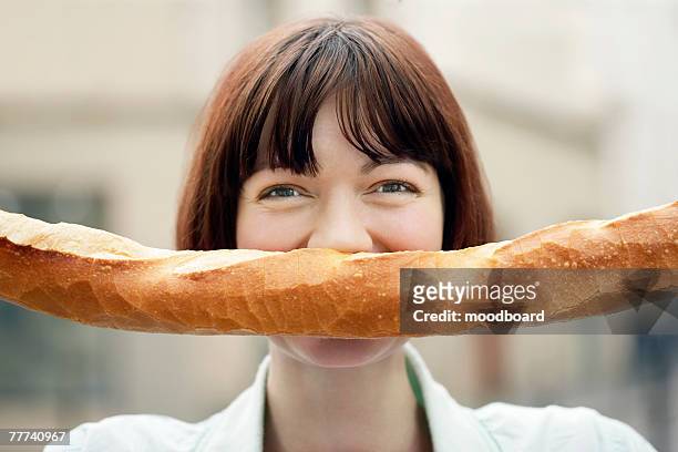 woman holding baguette in front of face - baguette white stock pictures, royalty-free photos & images