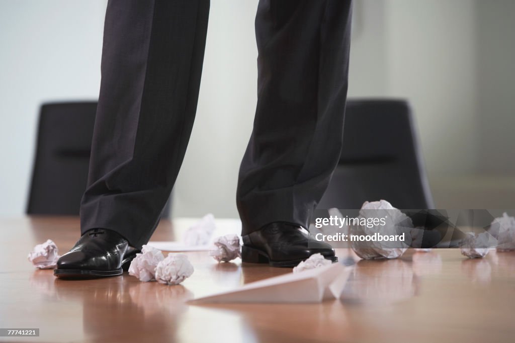 Businessman Standing on Desk