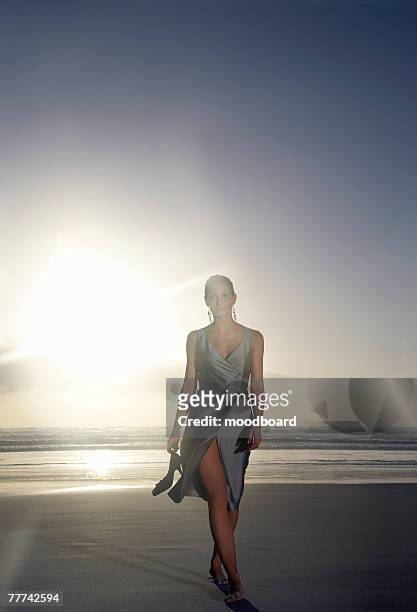 elegant woman walking on the beach - beach glamour stock pictures, royalty-free photos & images
