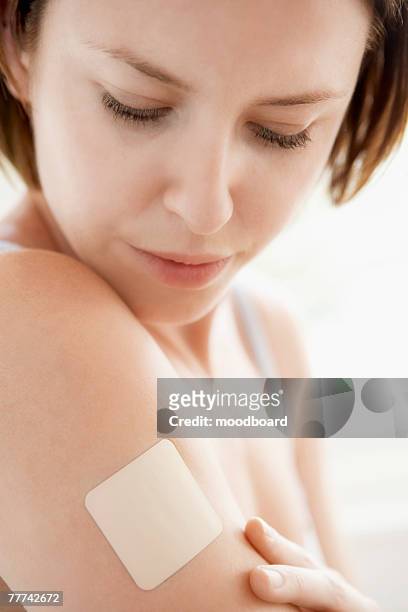 woman with patch on arm - contraceptive patch stock pictures, royalty-free photos & images