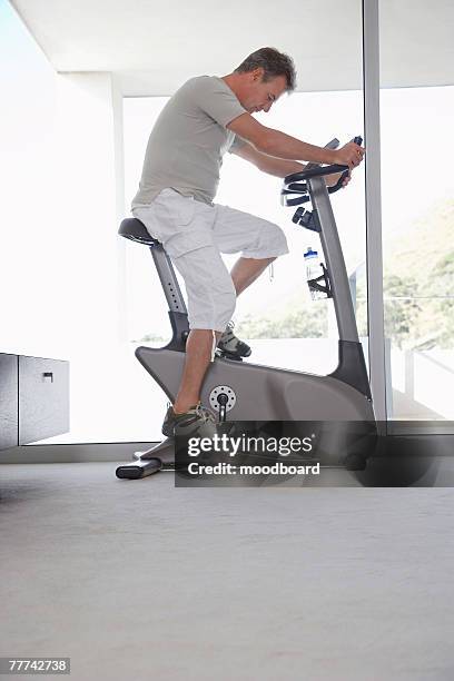 man on exercise bicycle - exercise bike stock pictures, royalty-free photos & images