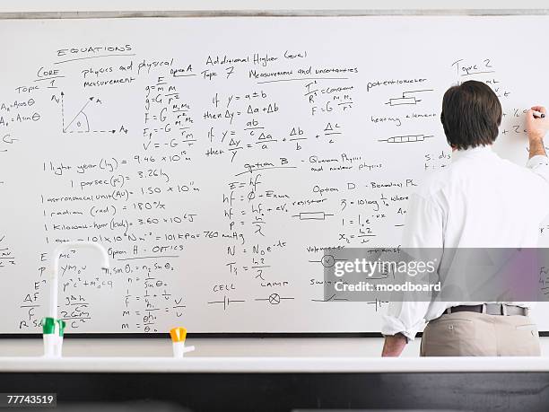 teacher writing on whiteboard - mathematician stockfoto's en -beelden