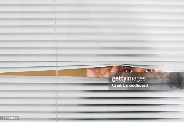 woman looking through venetian blinds - peer bildbanksfoton och bilder