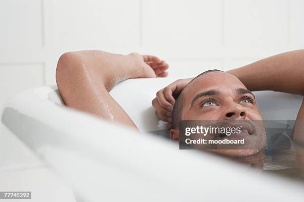 man relaxing in bathtub - lavarse el cabello fotografías e imágenes de stock