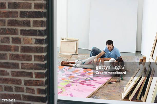 couple looking at painting in studio - young artists unite fotografías e imágenes de stock