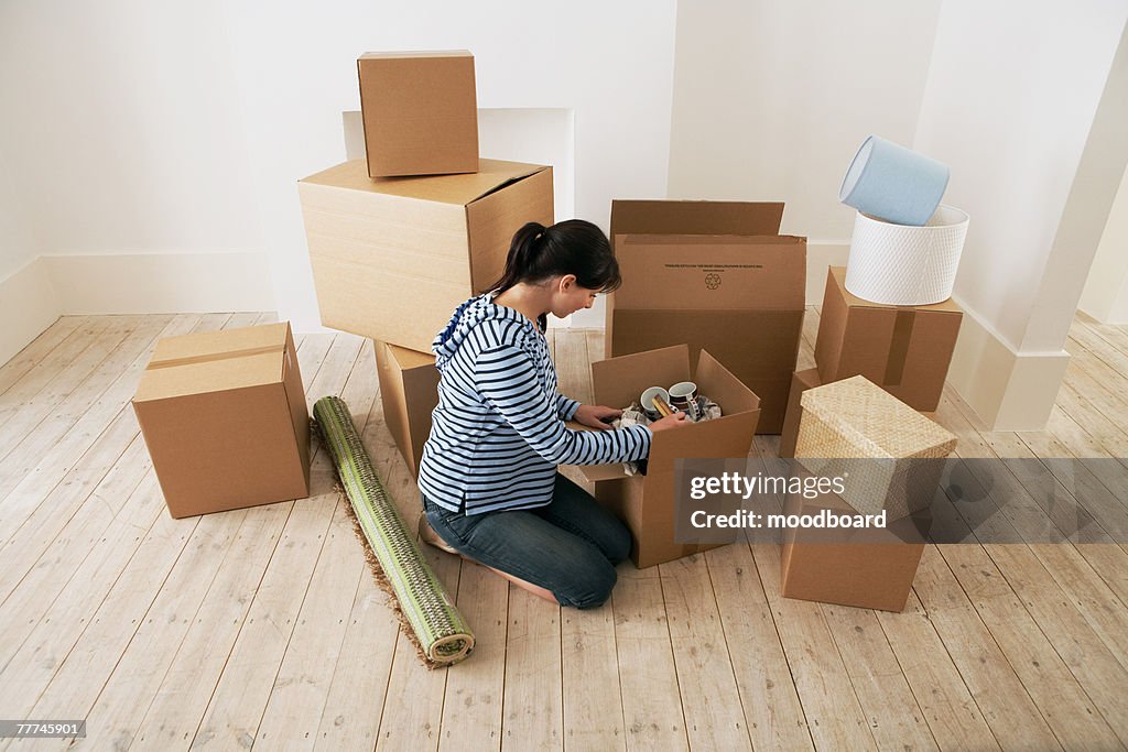 Woman Looking at Contents of Moving Boxes