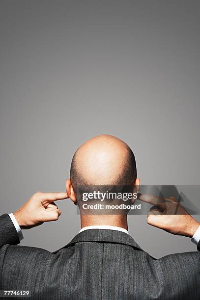 businessman plugging his ears - fingers in ears 個照片及圖片檔