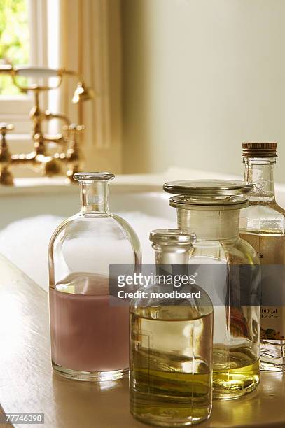 bottles of bath oils by bubble bath - bubble bath bottle stock pictures, royalty-free photos & images