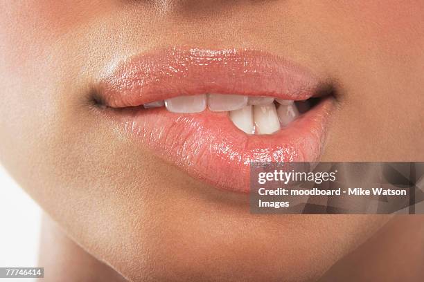 woman biting lip - labios fotografías e imágenes de stock