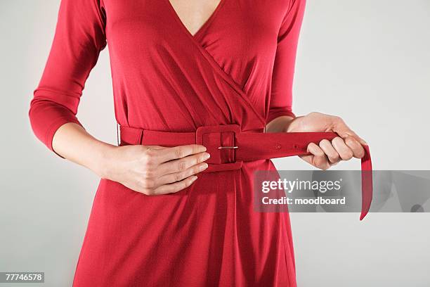 businesswoman cinching belt - ceintuur stockfoto's en -beelden