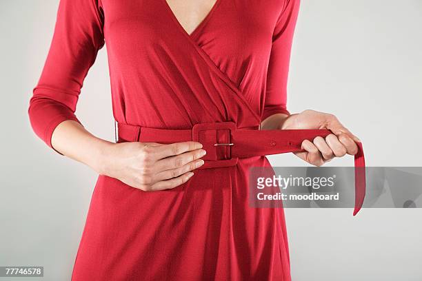 businesswoman cinching belt - belt stock pictures, royalty-free photos & images