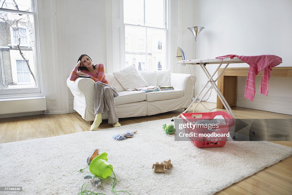 Pensive Housewife in Messy Living Room