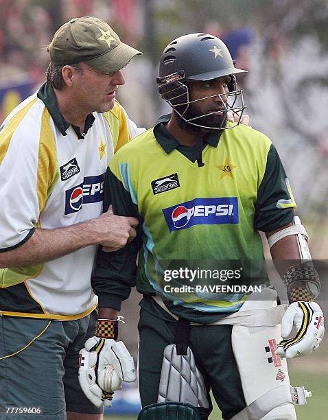 Pakistani cricket coach Geoff Lawson chats with cricketer Mohammad Yousuf during a training session at the Mohali Cricket Stadium in Mohali, 07...