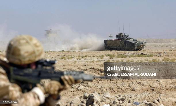 British soldiers patrol the area on foot and in a tank as Iraqi soldiers hold the opening ceremony of the 14th Iraqi army Division headquarters in...