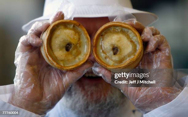 John Young a judge at the World Scotch Pie Championship jokes with pies during judging at Lauder College November 7, 2007 in Dunfermline, Scotland. A...