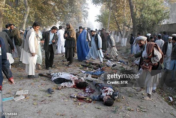 Afghans walk between the dead bodies from a suicide attack in Baghlan north east of Kabul, 06 November 2007. The death toll from Afghanistan's...