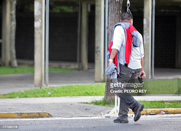 Young man walks with a gun in his hand after clashes between opposition university students and pro-Chavez students before of a march toward...