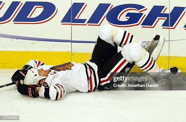 Kevyn Adams of the Chicago Blackhawks lies on the ice after he was injured during the first period against the Columbus Blue Jackets at the United...