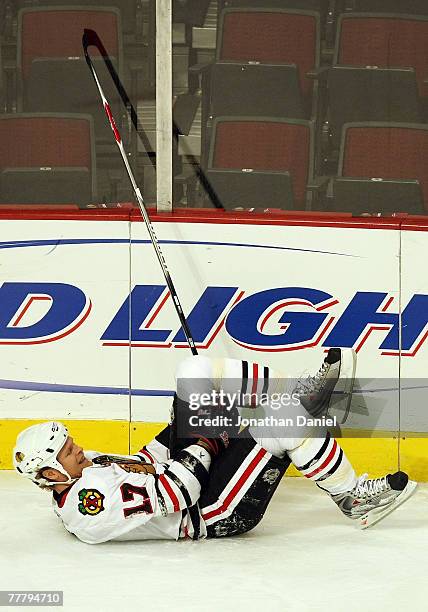 Kevyn Adams of the Chicago Blackhawks grabs his left knee as he lies on the ice after he was injured during the first period against the Columbus...