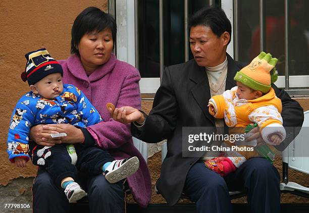 Children suffering from cleft lip and palate wait for an examination at the Nanjing Drum Tower Hospital during registration for treatment at a...