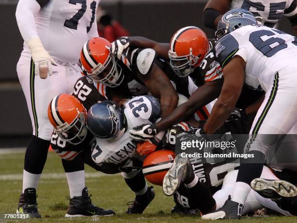 Running back Shaun Alexander of the Seattle Seahawks is gang-tackled by Sean Jones, Kamerion Wimbley, Leon Williams, and Robaire Smith of the...