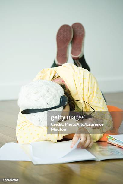 young woman lying on floor listening to headphones, head on arm - 頭隠して尻隠さず ストックフォトと画像