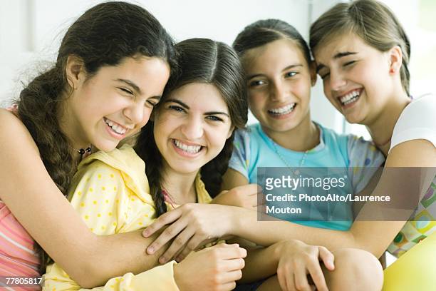 four young female friends laughing, arms around each other - girl 11 12 laughing close up foto e immagini stock