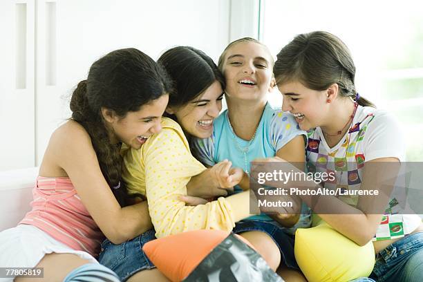 four young female friends tickling each other and giggling - girl 11 12 laughing close up foto e immagini stock