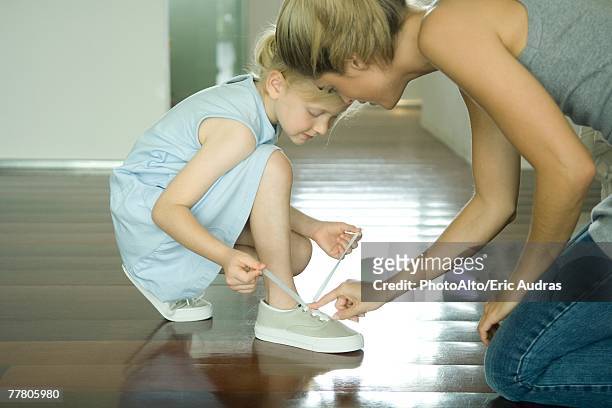 mother helping little girl tie shoe laces - shoelace stock pictures, royalty-free photos & images