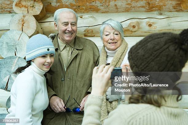 teenage girl photographing grandparents and sister with digital camera, waist up - close to camera stock pictures, royalty-free photos & images