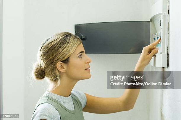 woman pushing lever in fuse box - clothes on clothes off photos 個照片及圖片檔