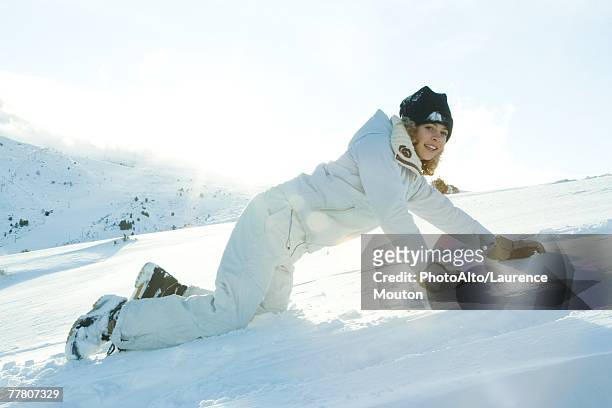 teenage girl down on all fours in snow, smiling at camera - northern european descent ストックフォトと画像