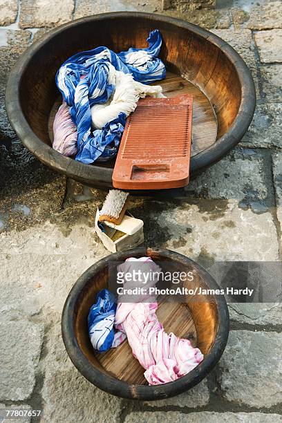 wash bassins with washboard and twisted wet laundry - washboard laundry stock pictures, royalty-free photos & images