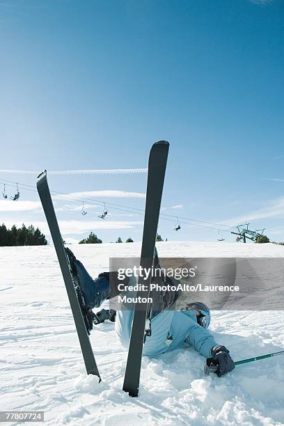young skier lying on back on the ground, legs in the air - skischoen stockfoto's en -beelden