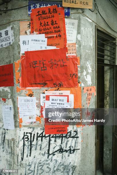 flyers in chinese pasted to wall - chinese red wall stock pictures, royalty-free photos & images