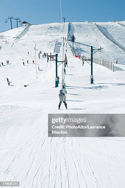 young skiers using ski lift . in the distance, rear view - tellerlift stock-fotos und bilder