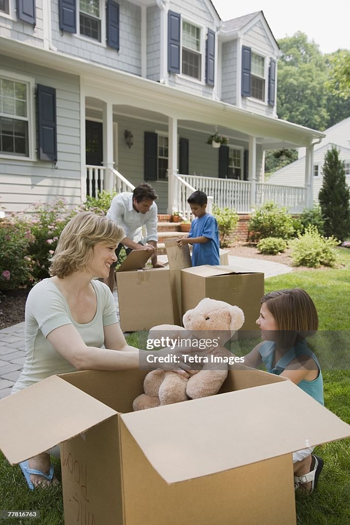 Family unpacking moving boxes