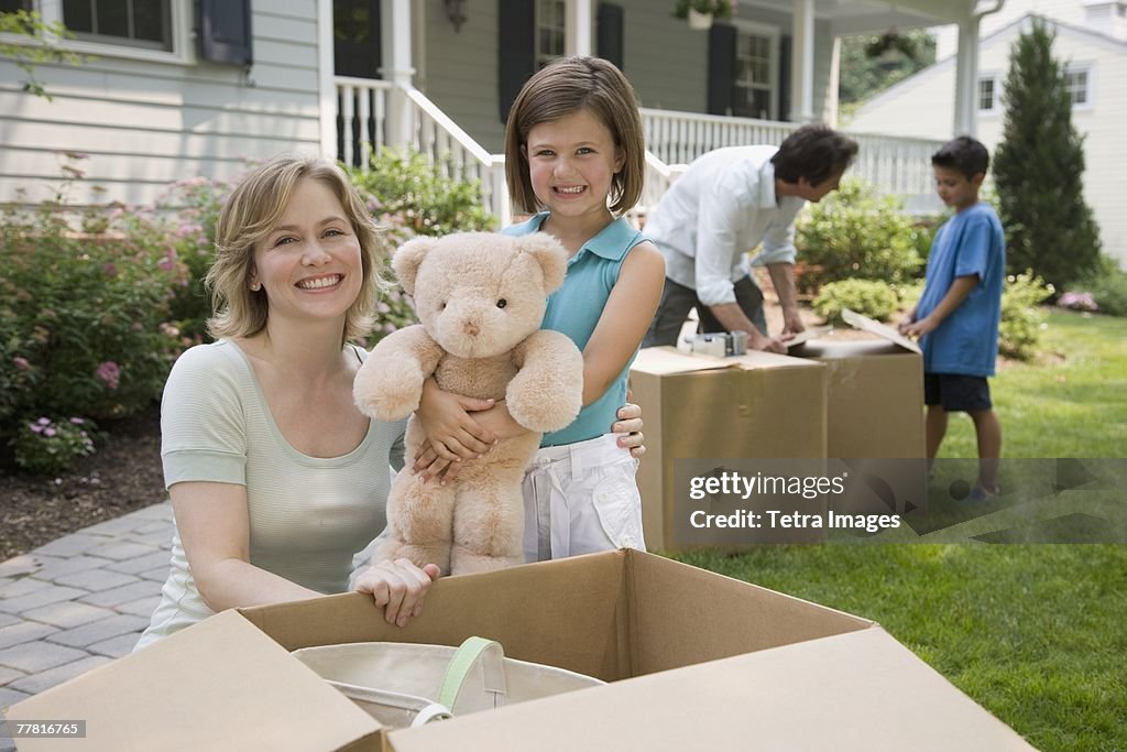 Family unpacking moving boxes