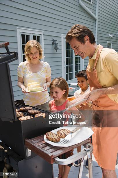 family barbequing on deck - open air dining stock pictures, royalty-free photos & images