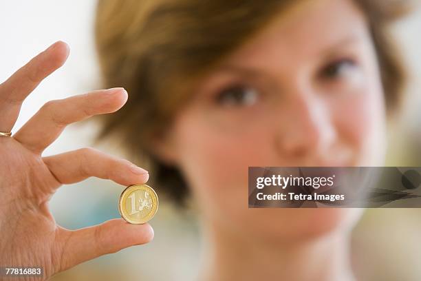 woman holding coin - 1 euro stock-fotos und bilder