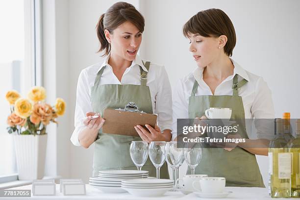 two female caterers with dishware - wedding planning foto e immagini stock
